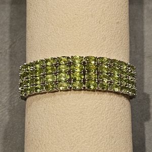 Natural Peridot 4-row tennis bracelet set in rhodium plated sterling silver.